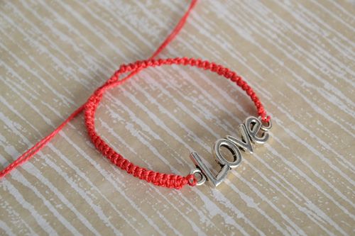 Handmade womens woven cord bracelet of red color with metal charm lettering - MADEheart.com