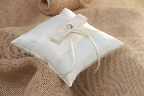 Tender handmade wedding ring pillow sewn of ivory-colored satin fabric with bow - MADEheart.com
