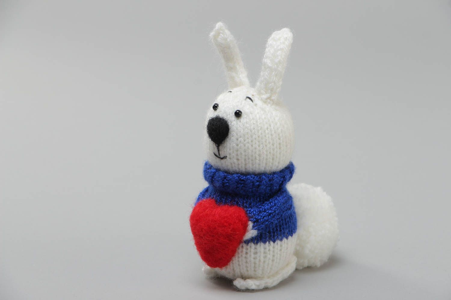 Handmade soft knitted white rabbit toy with a red heart for children photo 2