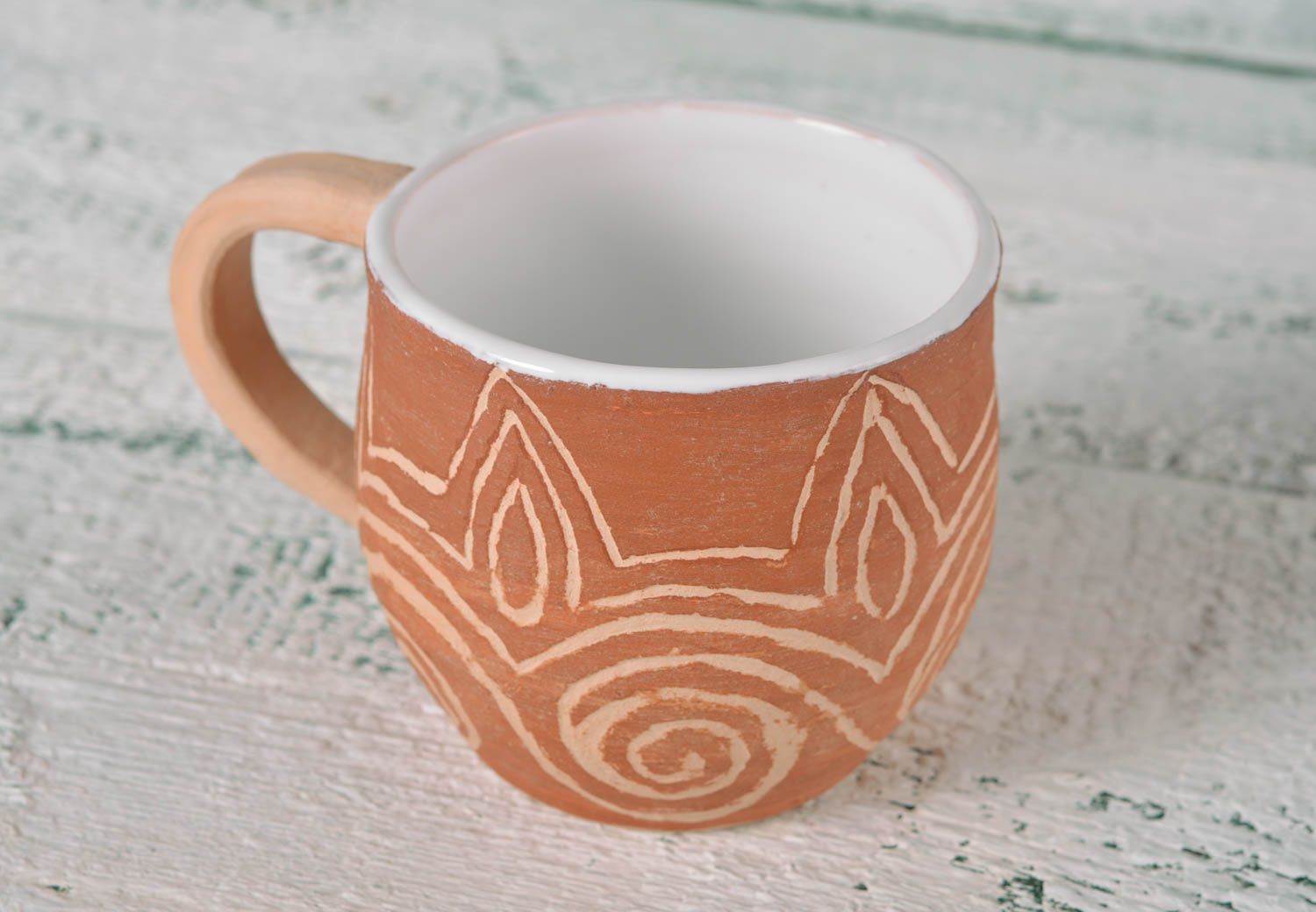 Rustic clay cup in white and brown color with handle and cave drawings photo 2