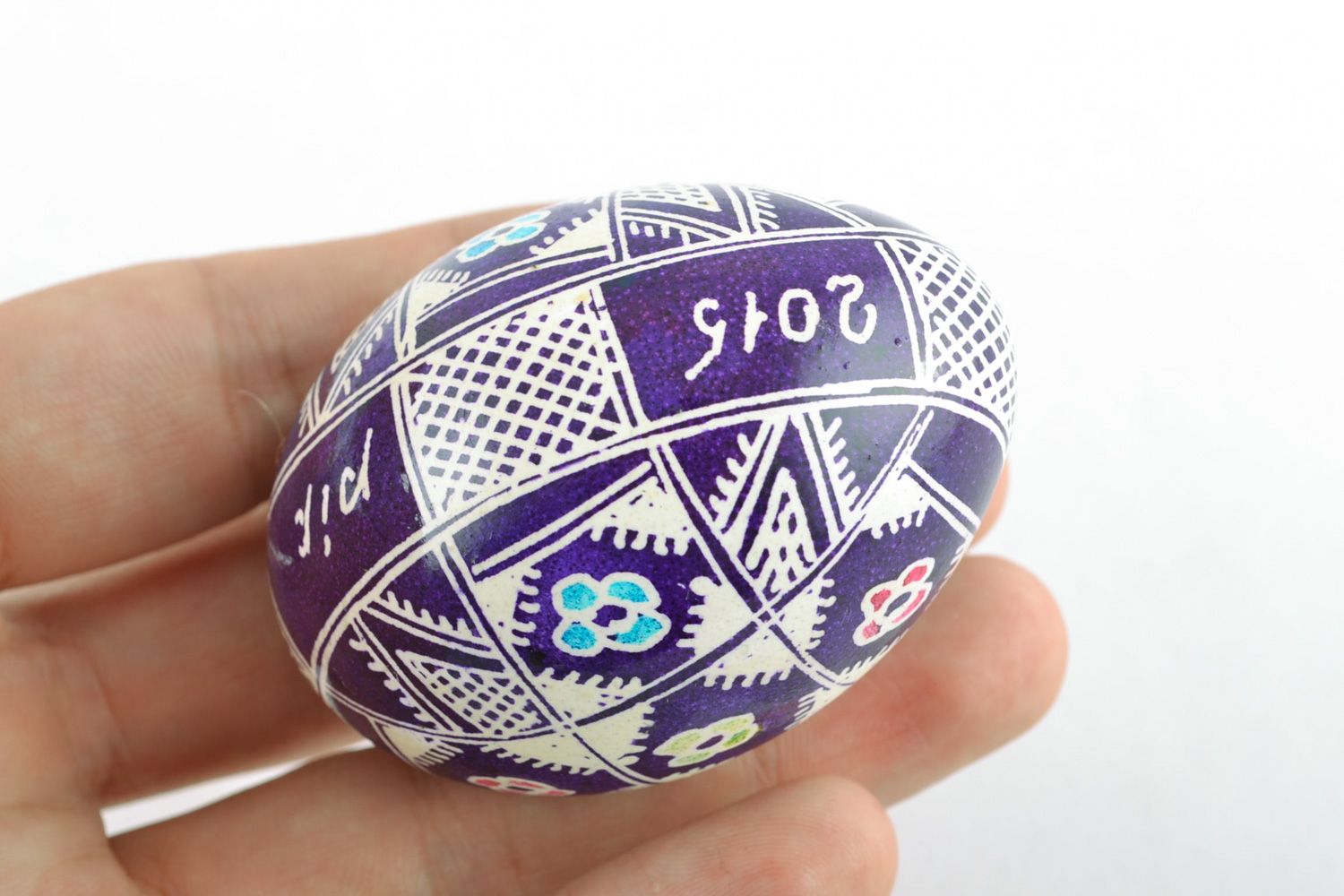 Handmade Easter egg with floral ornament painted with wax in violet color palette photo 2