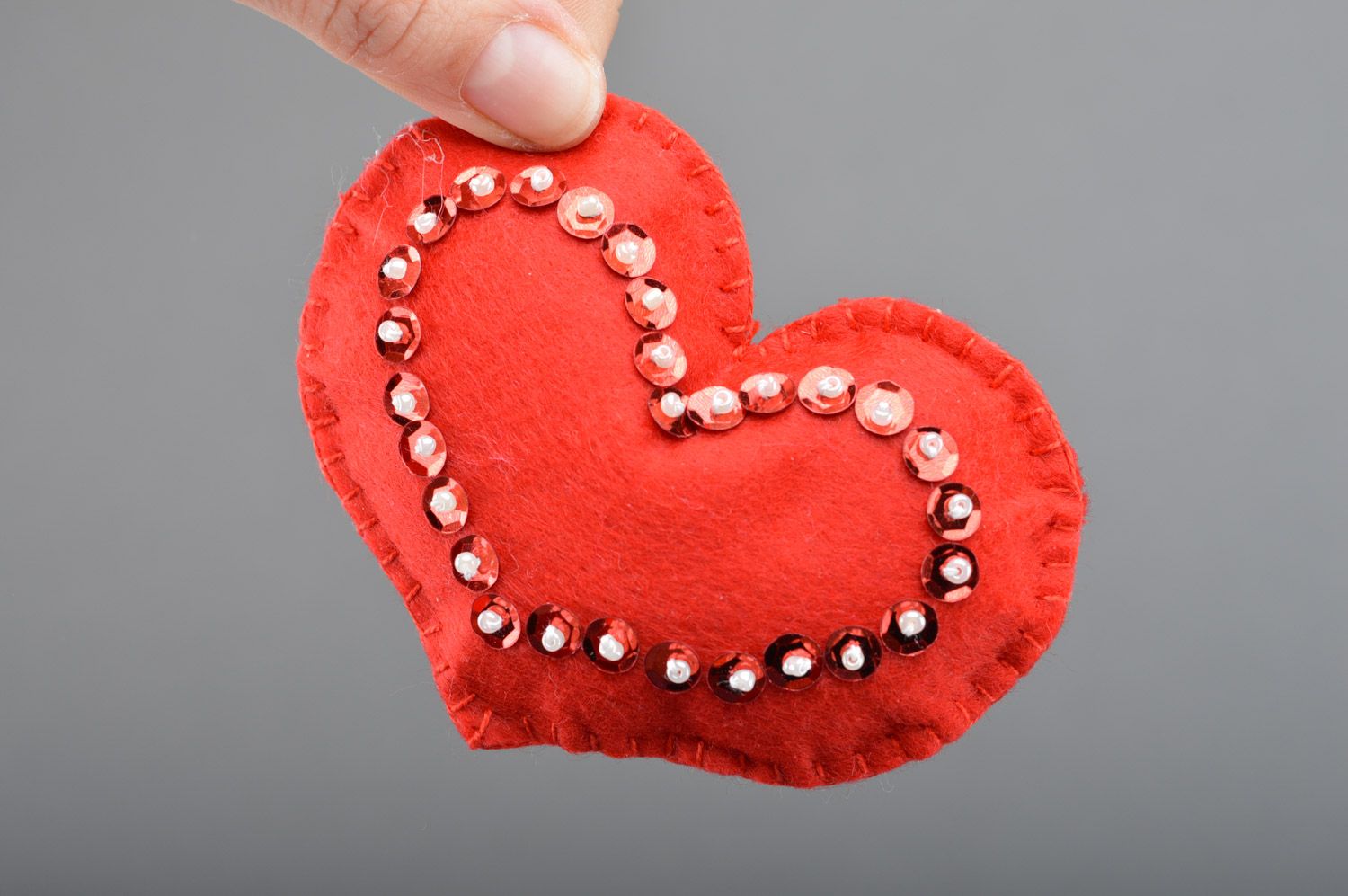 Handmade soft toy heart sewn of red felt decorated with spangles for interior photo 3
