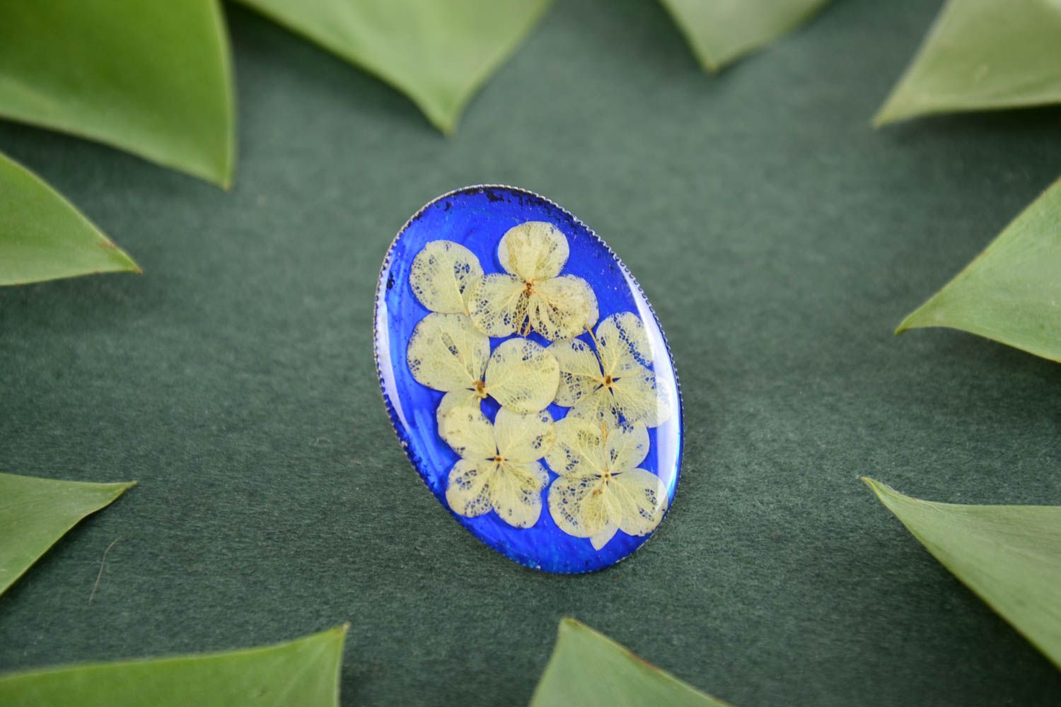Handmade oval ring with dried flowers on bright blue basis in epoxy resin photo 1