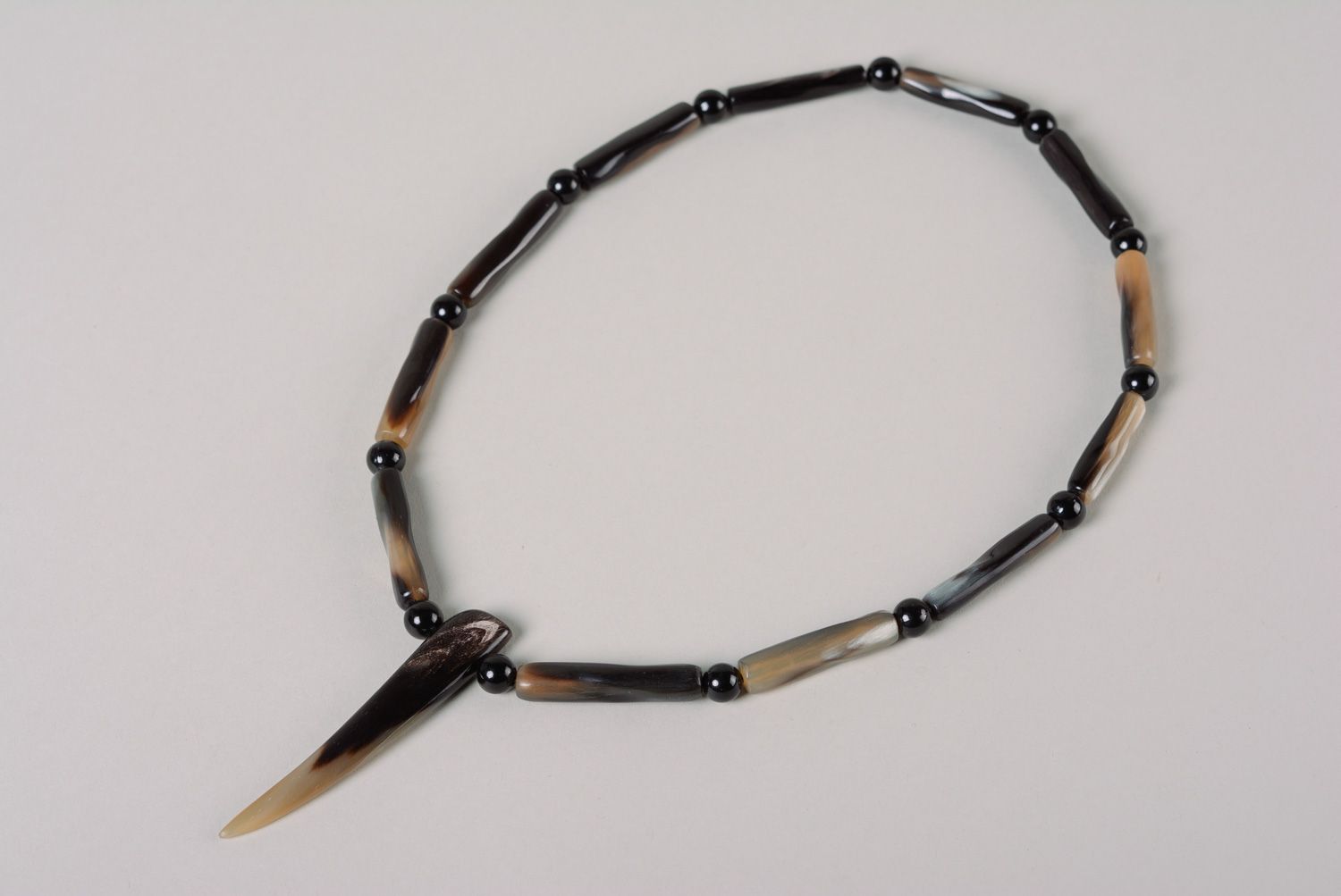 Handmade women's cow horn necklace in gray color palette in ethnic style photo 2
