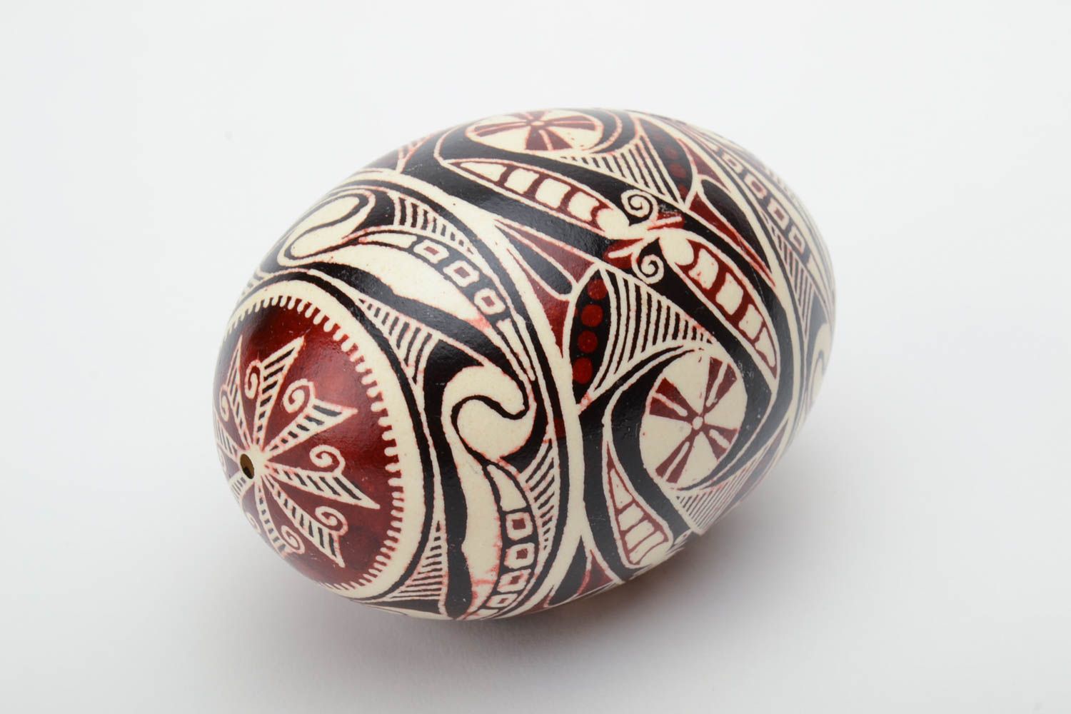 Handmade painted goose egg of black white and red colors ornamented using waxing technique photo 2
