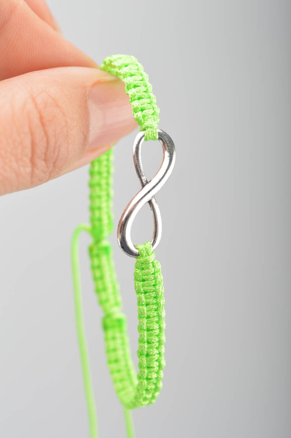 Beautiful handmade woven silk thread bracelet of lime color with metal charm photo 3