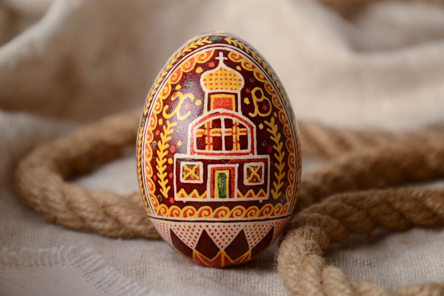 Huevo de gallina artesanal pintado en la técnica de encerado con iglesia y cruz foto 1