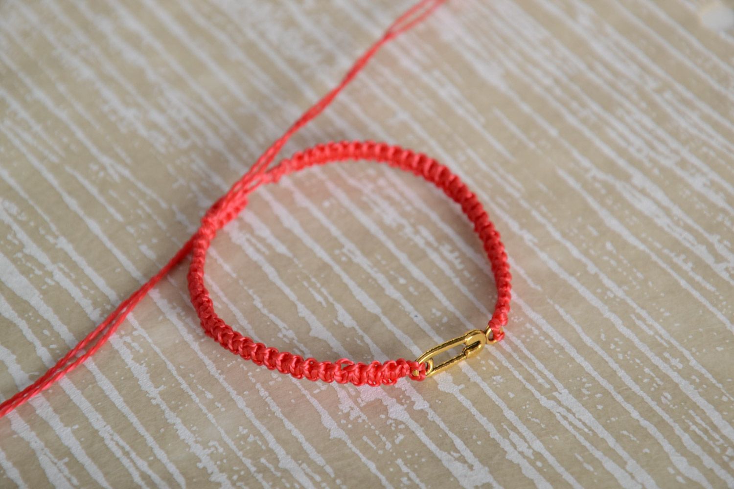 Handmade women's woven thread bracelet of red color with metal pin charm photo 1