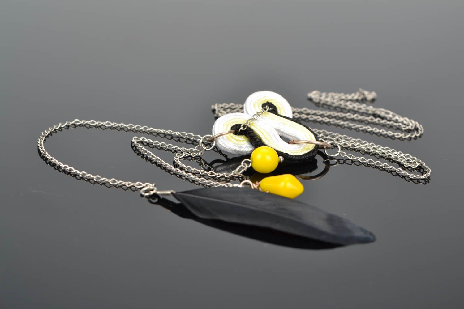 Pendant with feather on a long chain photo 1