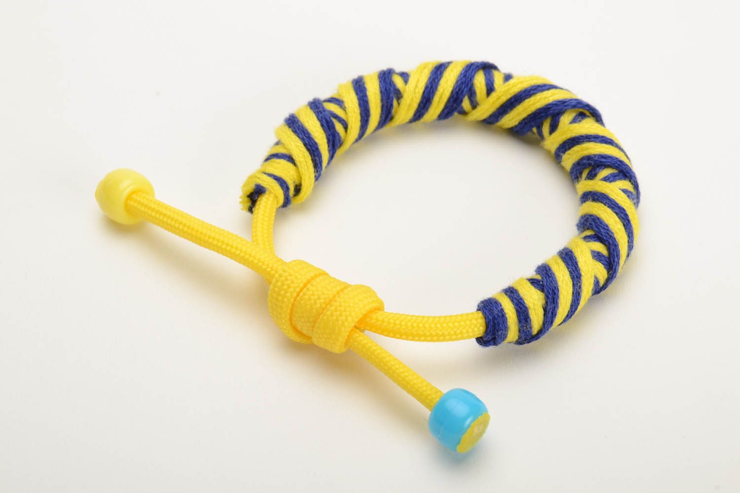 Pulsera artesanal trenzada de hilos mouliné con paracord de colores azul y amarillo  foto 2
