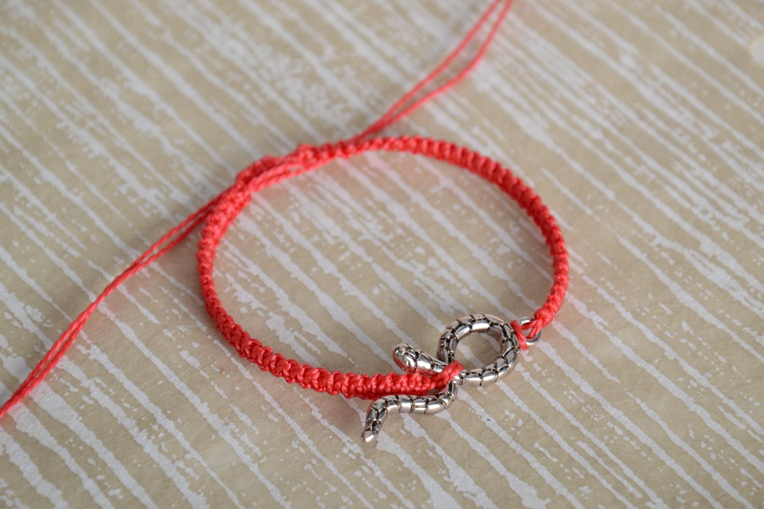 Handmade designer women's macrame bracelet of red color with metal snake charm photo 1