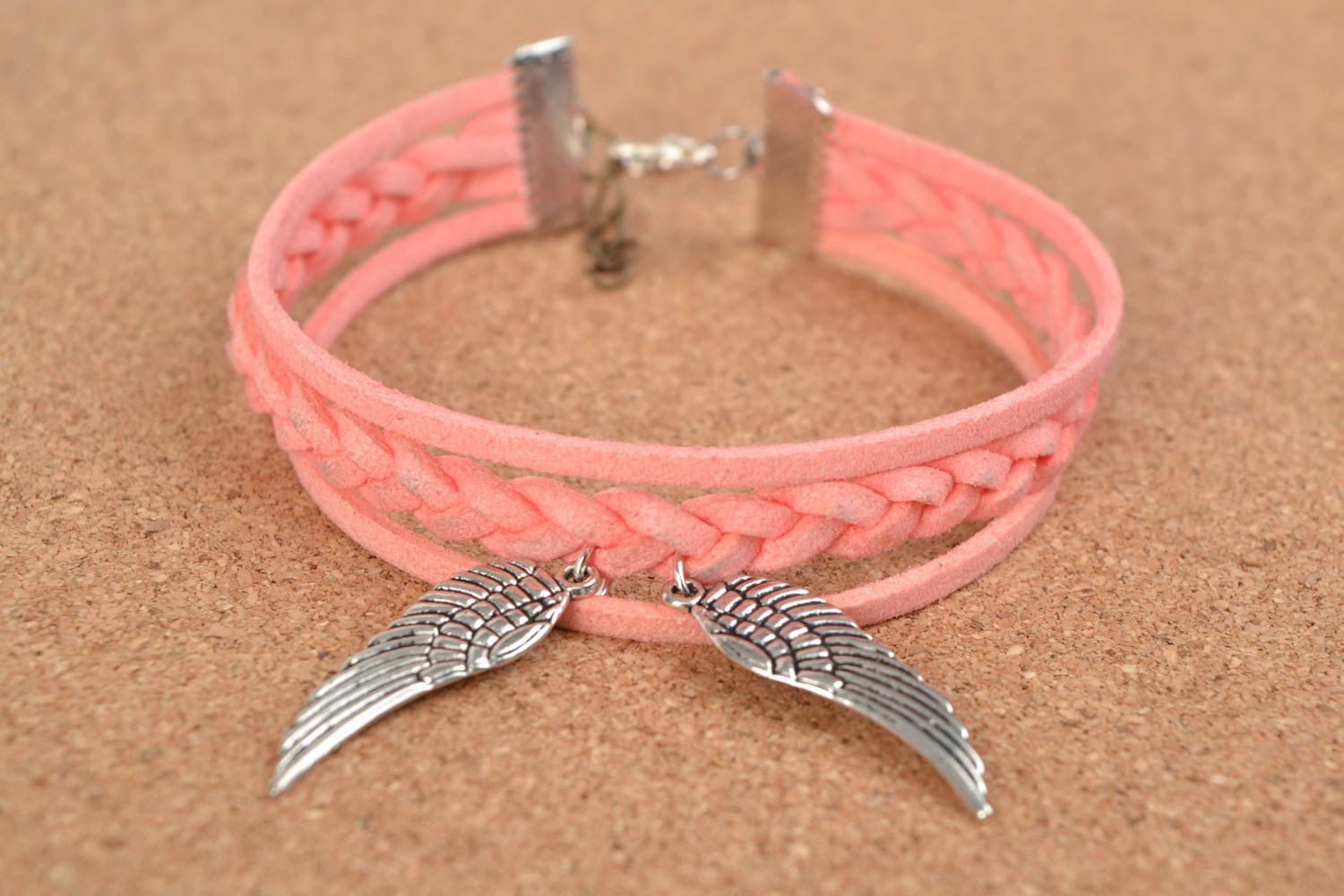 Pink handmade woven suede bracelet with metal charm in the shape of wings photo 1