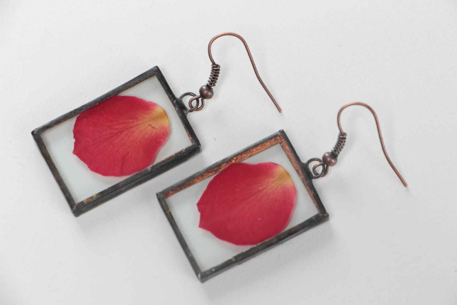 Pendientes artesanales rectangulares con pétalos rojos bajo el cristal foto 2