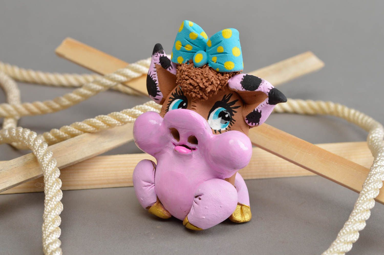 Глиняный сувенир ручной работы застенчивая розовая свинка с голубым бантом фото 1