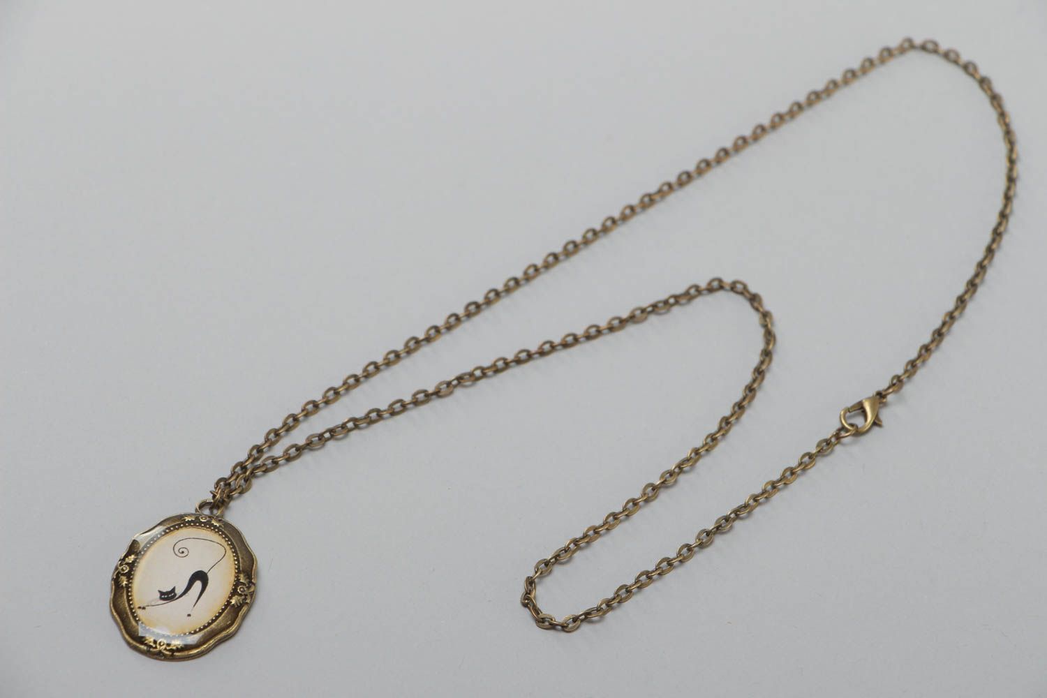 Joli pendentif ovale beige original avec longue chaîne en métal Chat noir photo 2