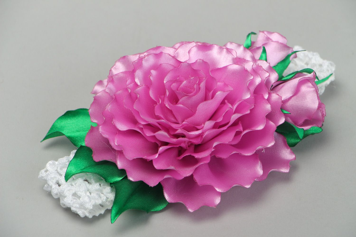 Bright elastic handmade headband with satin flower of pink color with green leaves photo 1