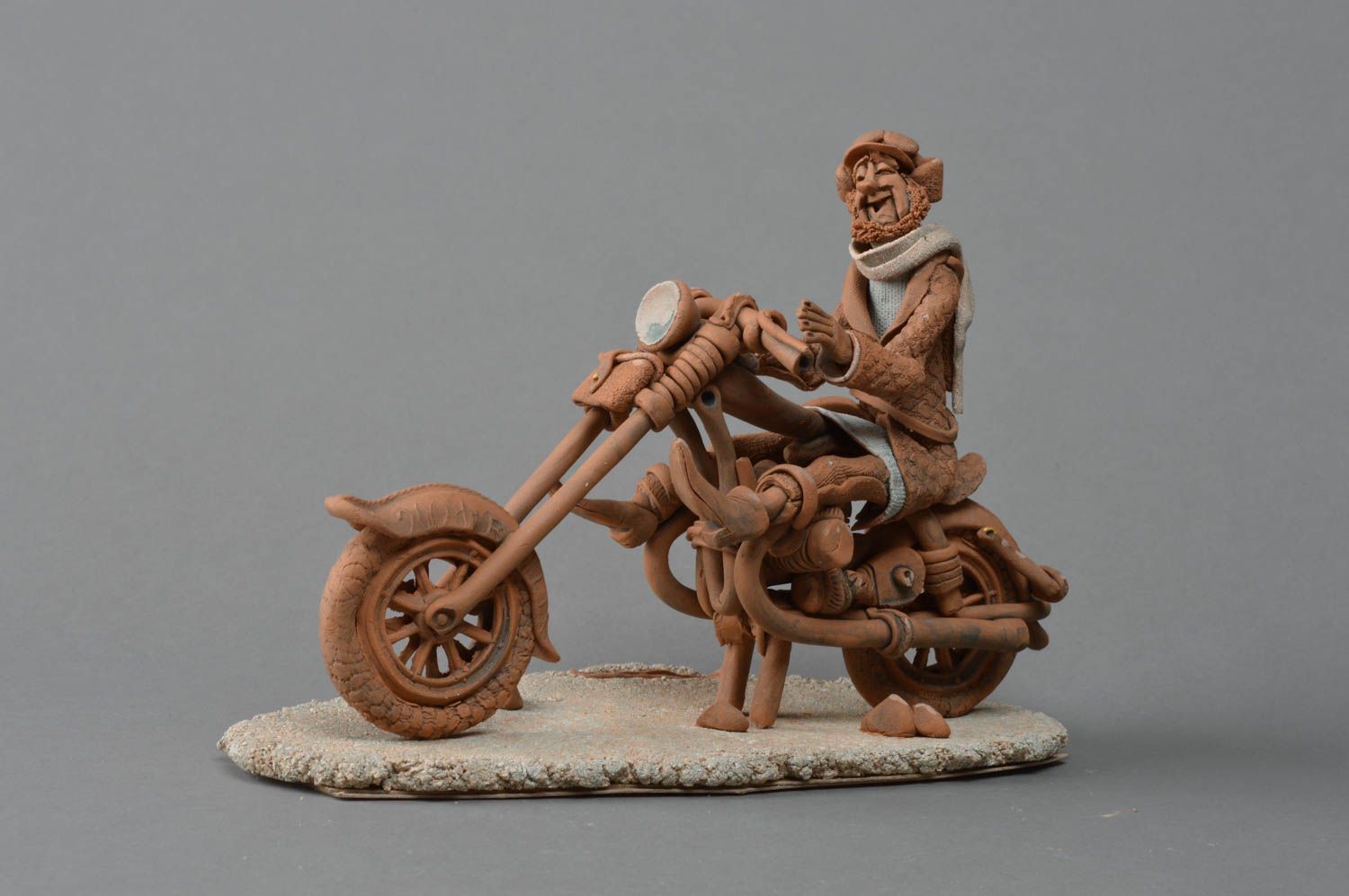 Ungewöhnliche keramische Statuette Mann mit Motorrad aus rotem und weißem Ton foto 1