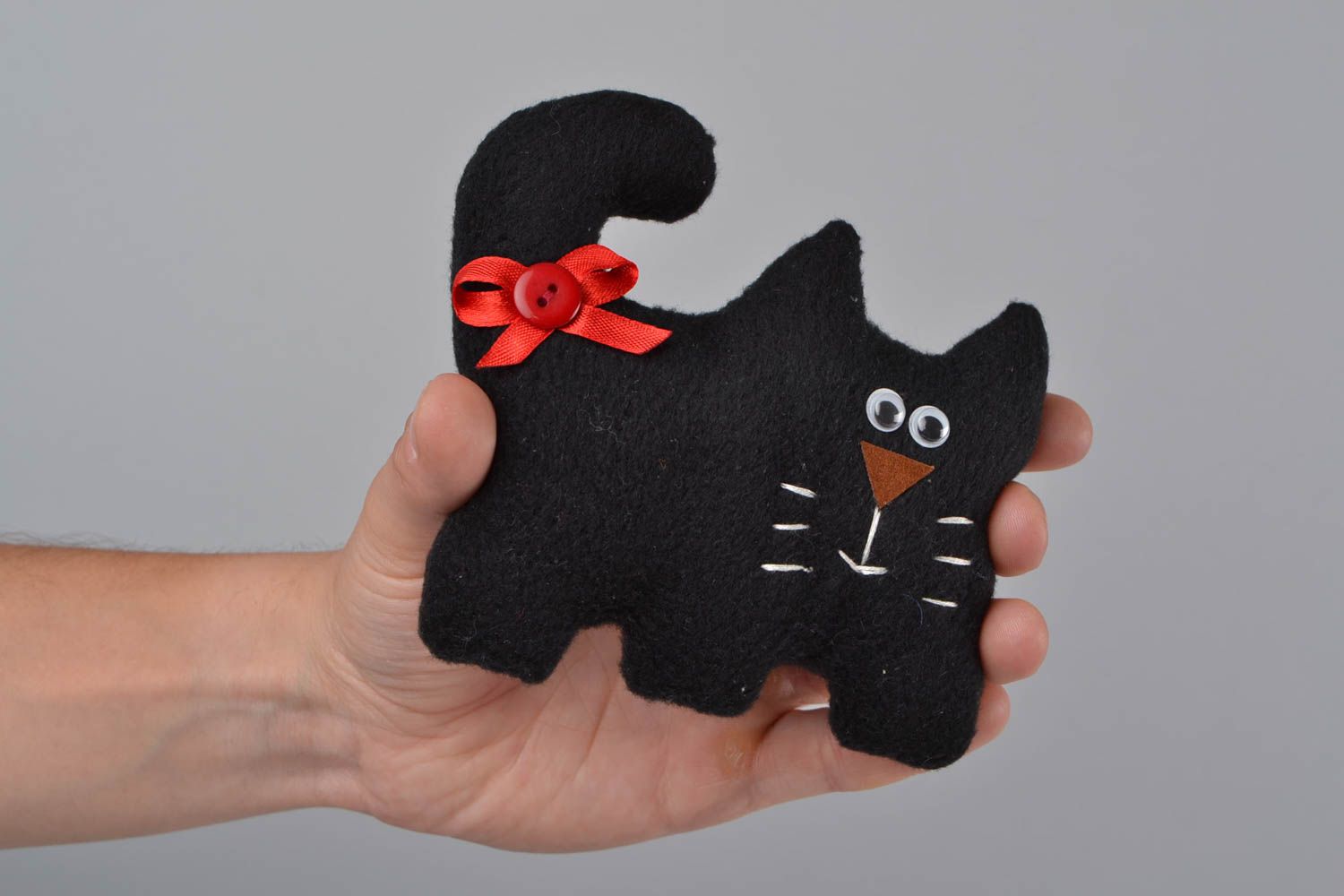 Handmade small soft toy sewn of black fleece in the shape of cat with red bow photo 2