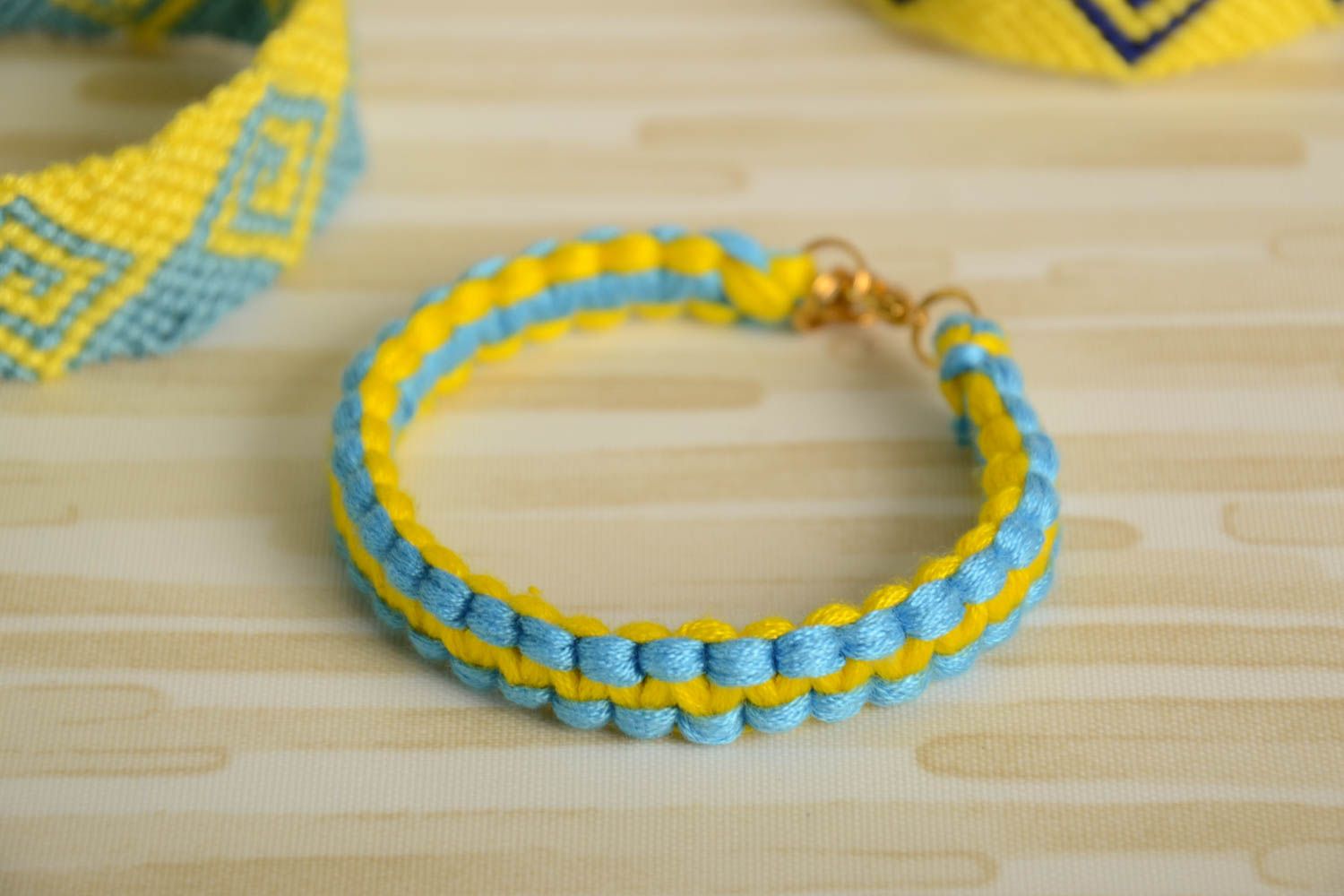 Тонкий плетеный браслет из ниток мулине желто-голубой ручной работы Кобра фото 1