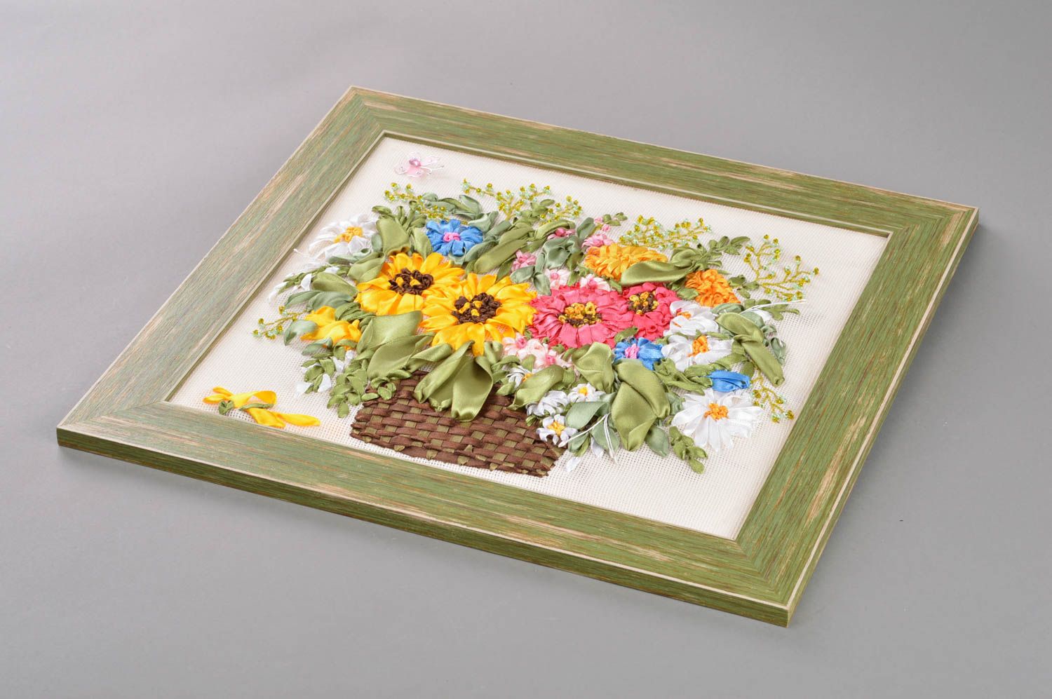 Gesticktes Gemälde mit bunten Blumen aus Atlasbändern in Plastik Frühlingsstrauß foto 1