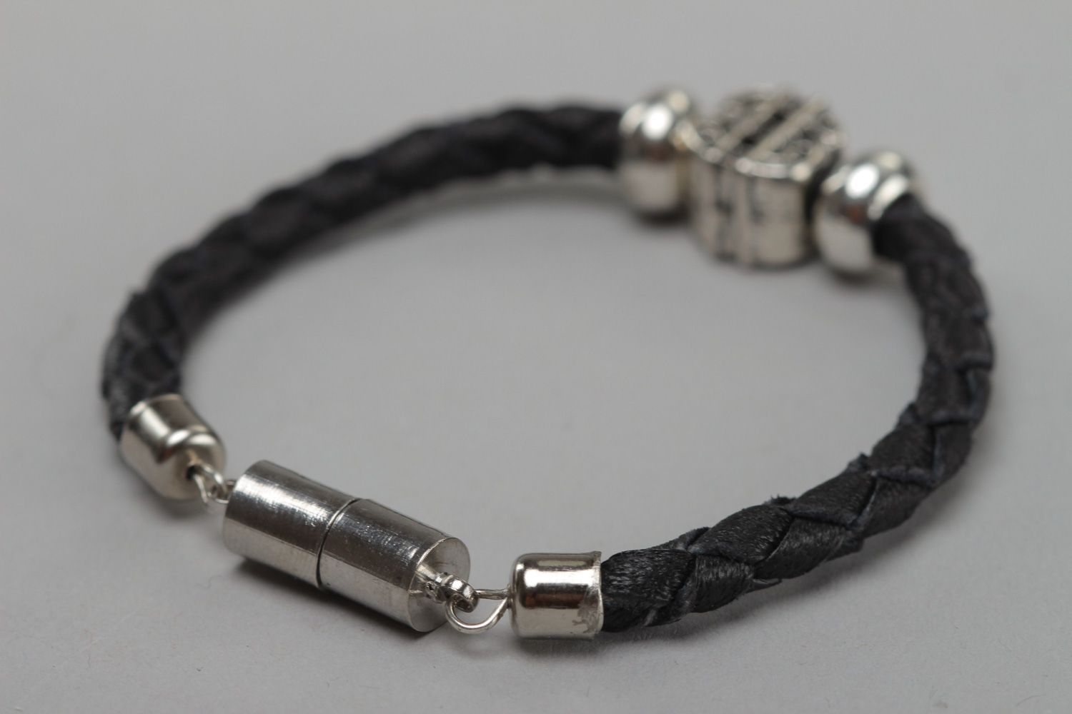 Thin black handmade wrist bracelet woven of genuine leather with metal inserts photo 4