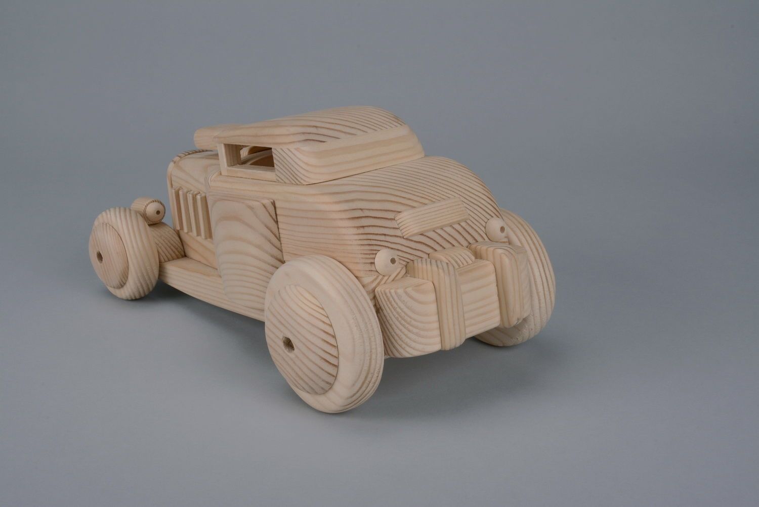 Cochecito de juguete tallado a mano de madera foto 3