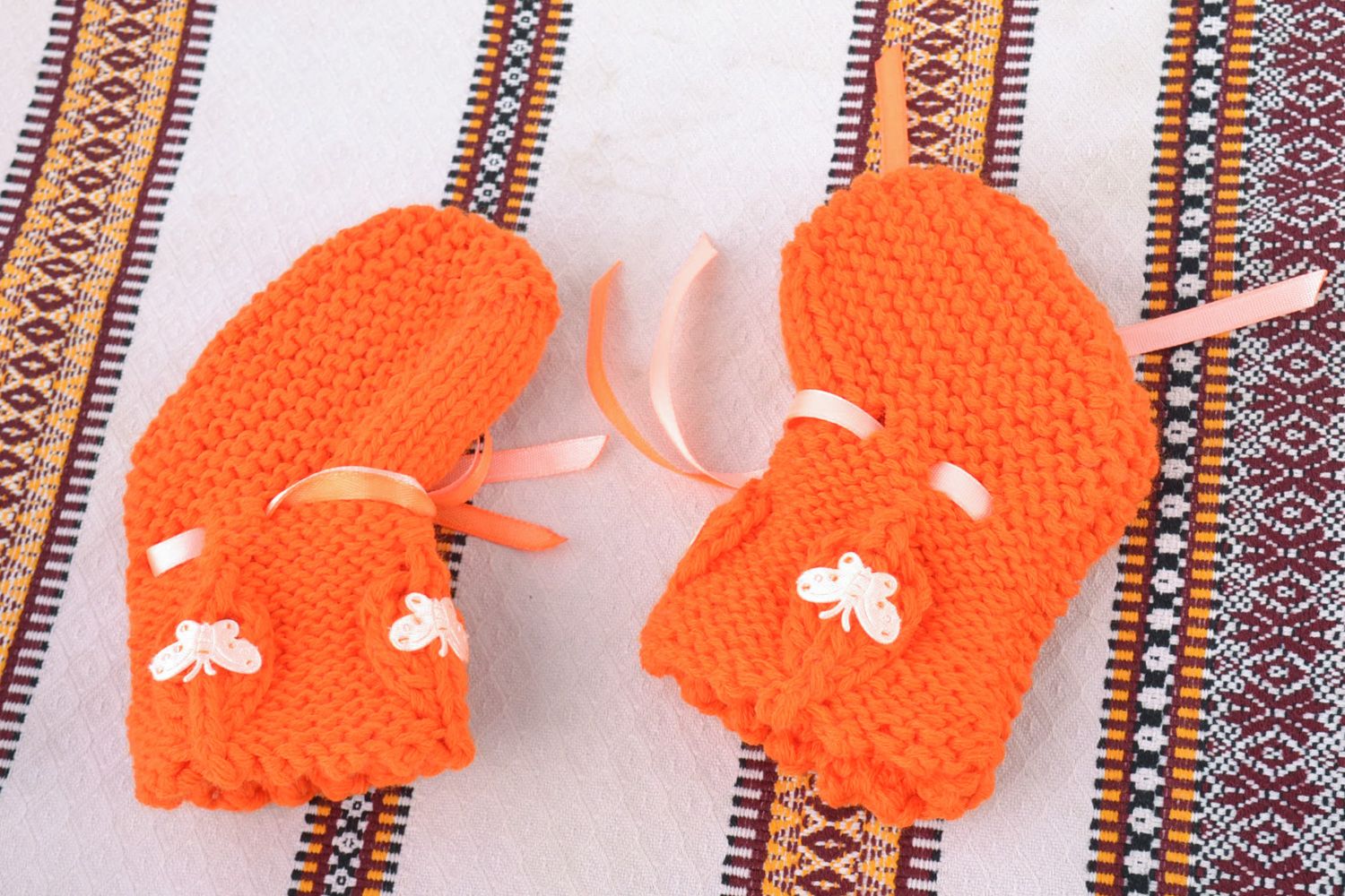 Handmade knitted wool baby bootees of orange color photo 1