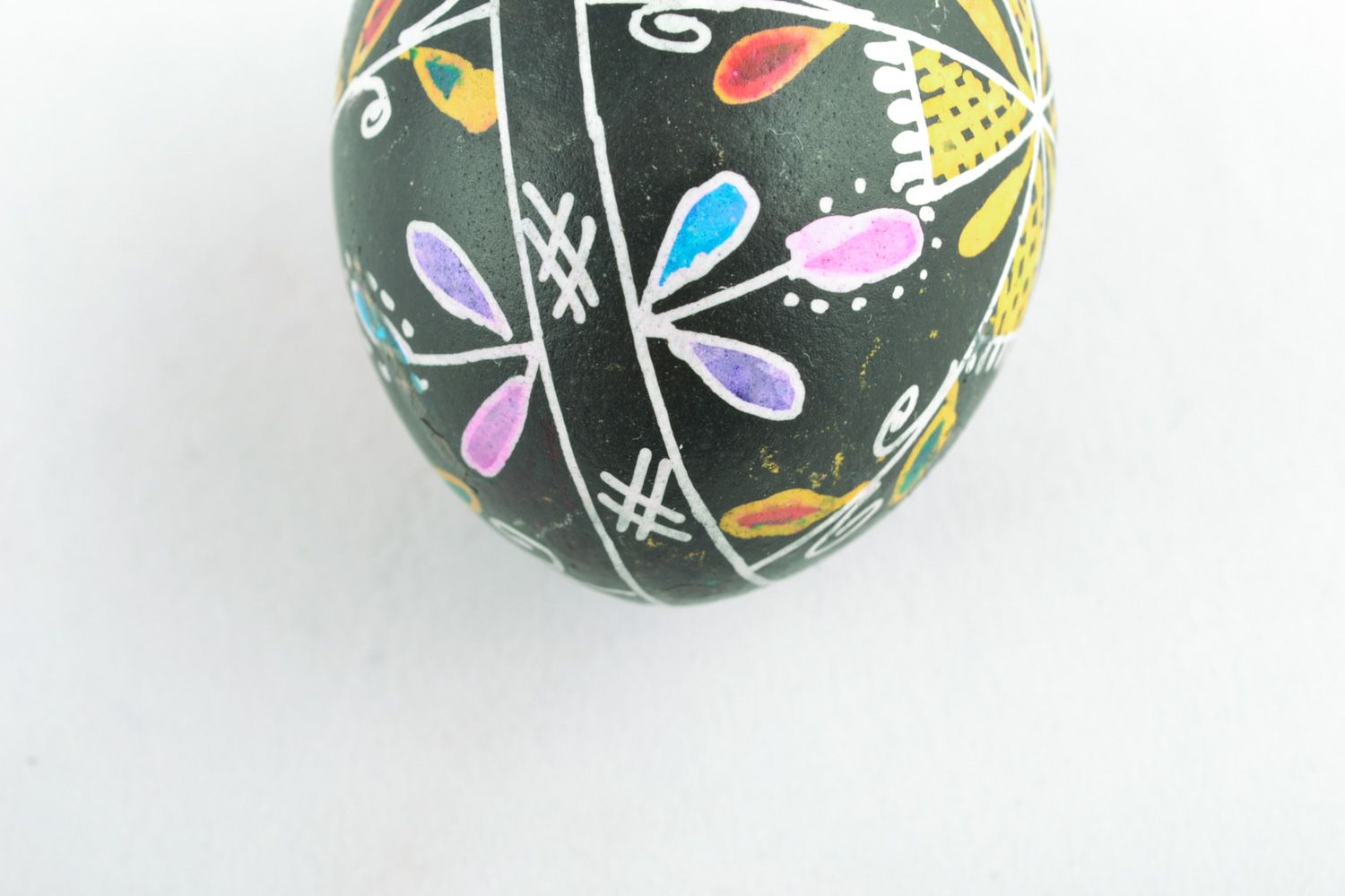 Handmade Easter egg with floral ornament on black background painted with wax photo 3