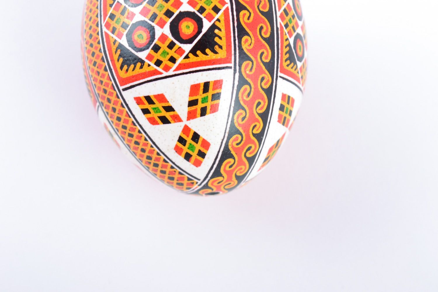 Huevo de Pascua pintado de gallina artesanal con ornamentos en fondo blanco foto 4