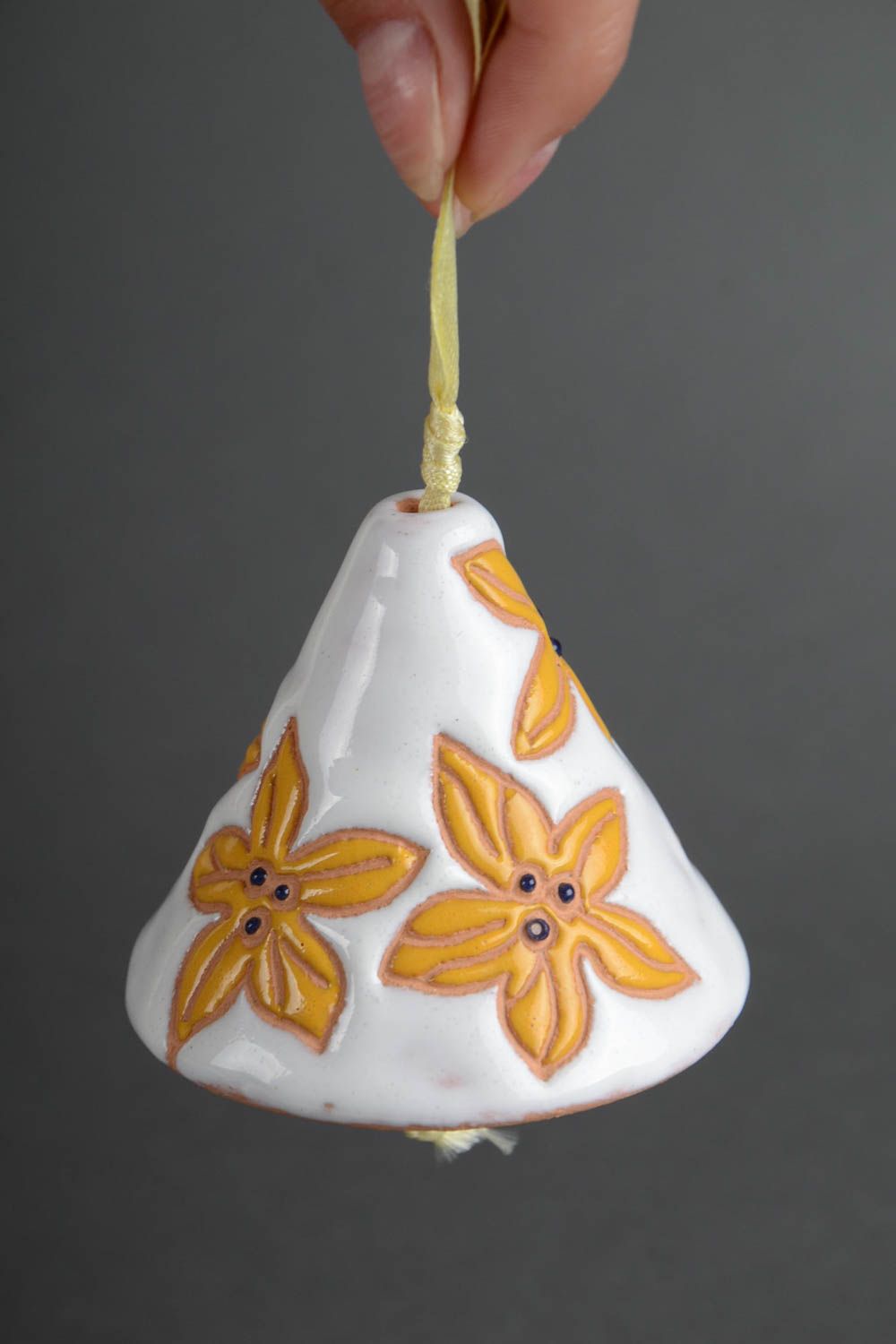 Handmade decorative ceramic bell painted with yellow flowers on white background photo 5
