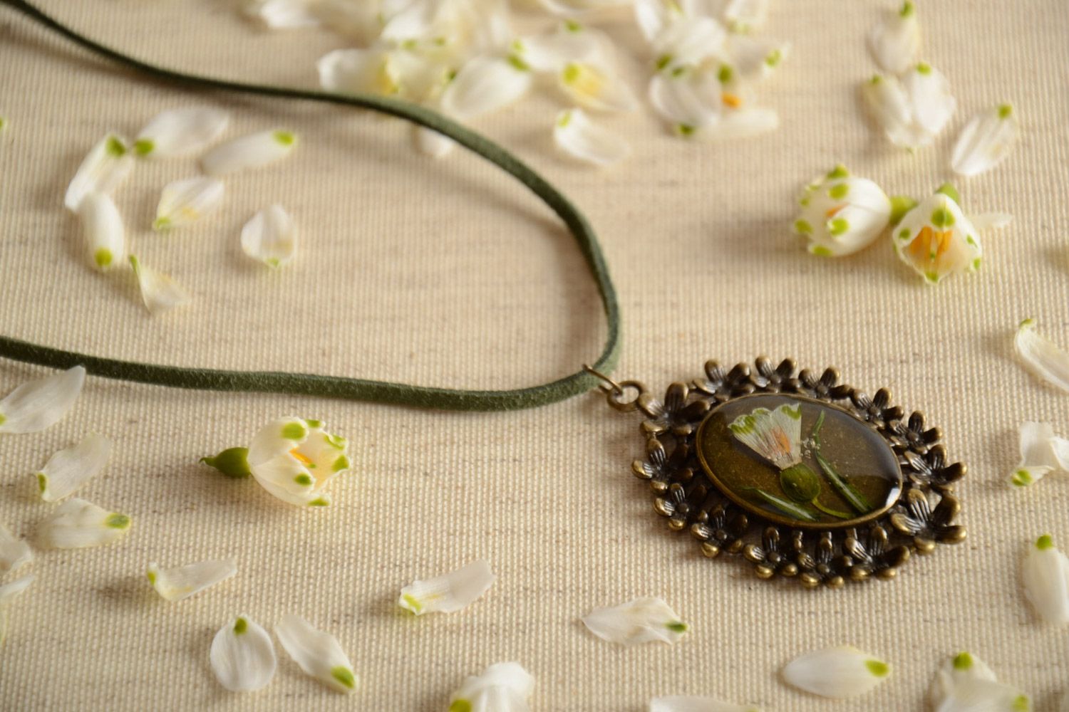 Handmade pendant with natural flower in epoxy resin on oval metal basis on cord photo 1
