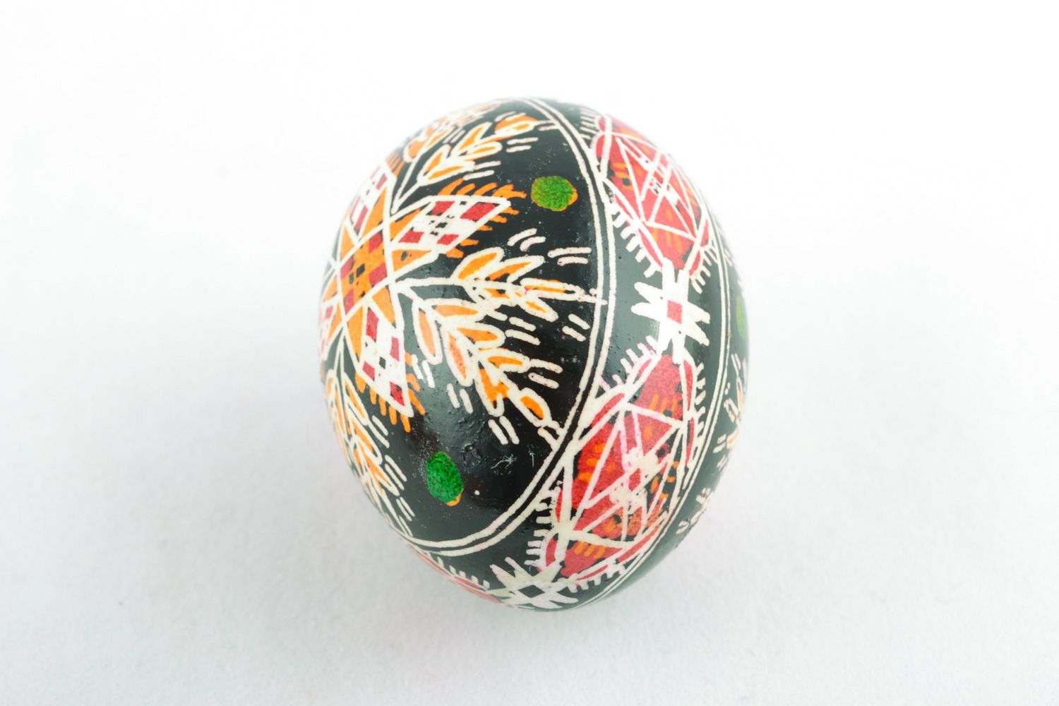 Handmade Easter egg with rich ornament on black background painted with hot wax  photo 2