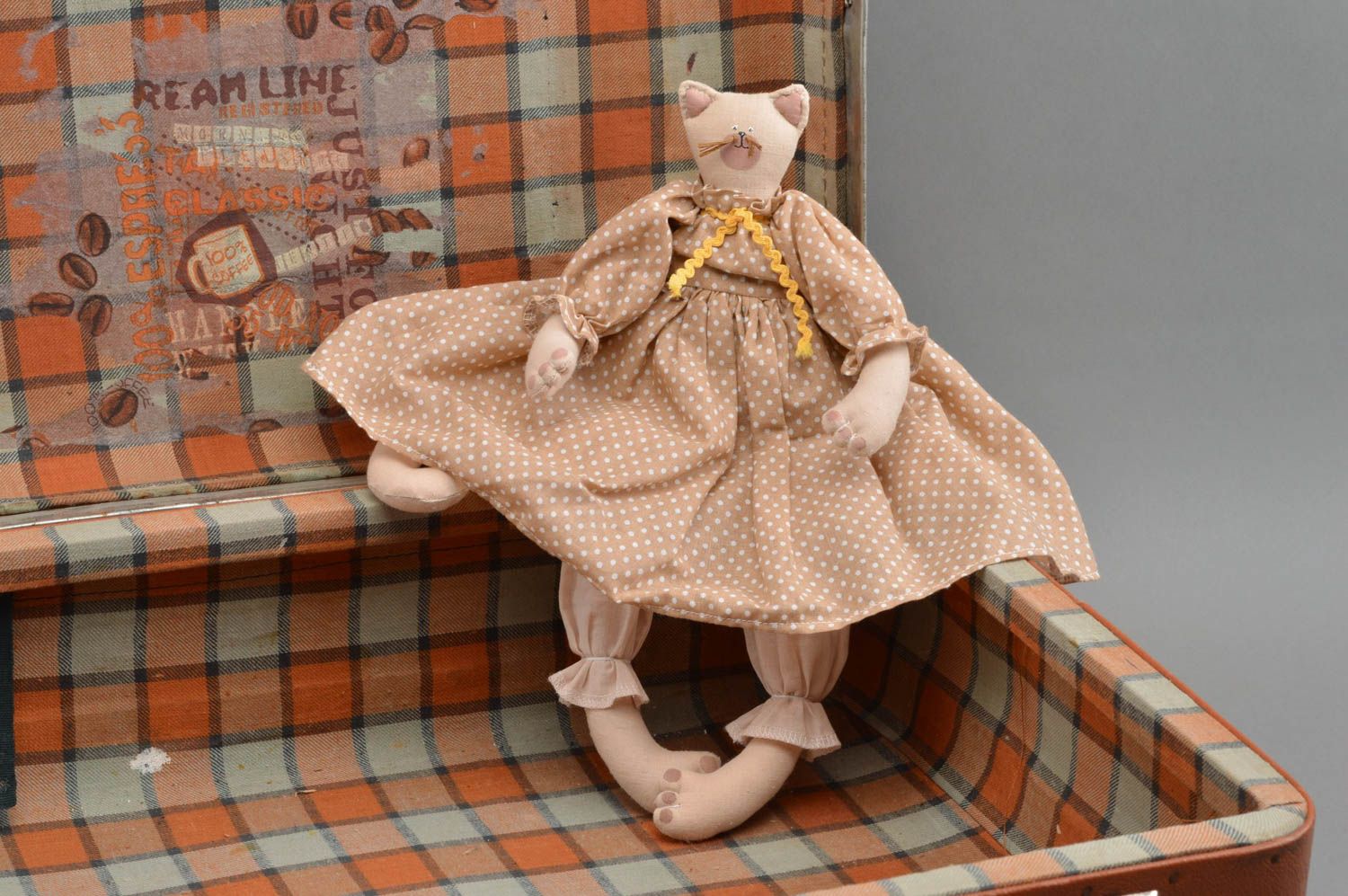 Handgemachtes Spielzeug aus Stoff Katze für Kinder im gepunkteten Kleid  foto 1