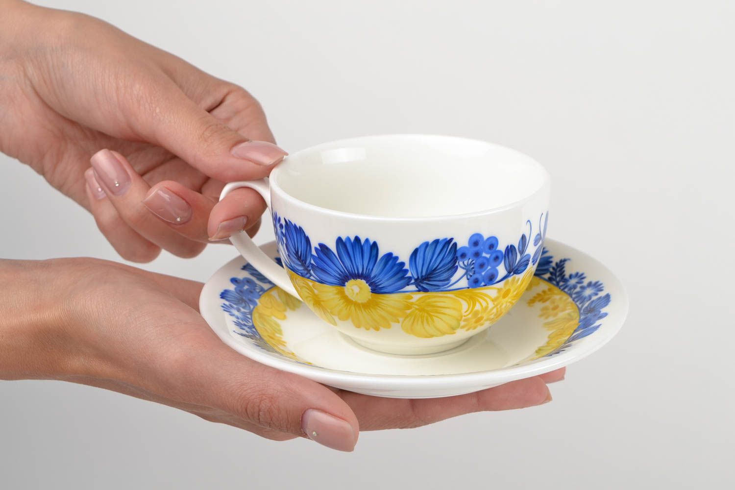 Porcelain yellow, white, and blue colors teacup in floral design with handle and saucer photo 2