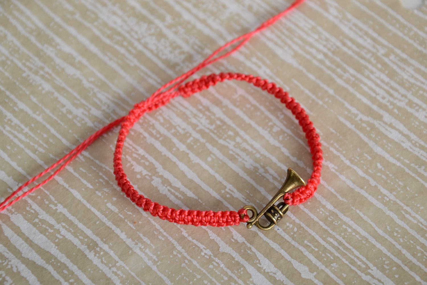 Handmade red woven capron thread bracelet with metal charm in the shape of saxophone photo 1