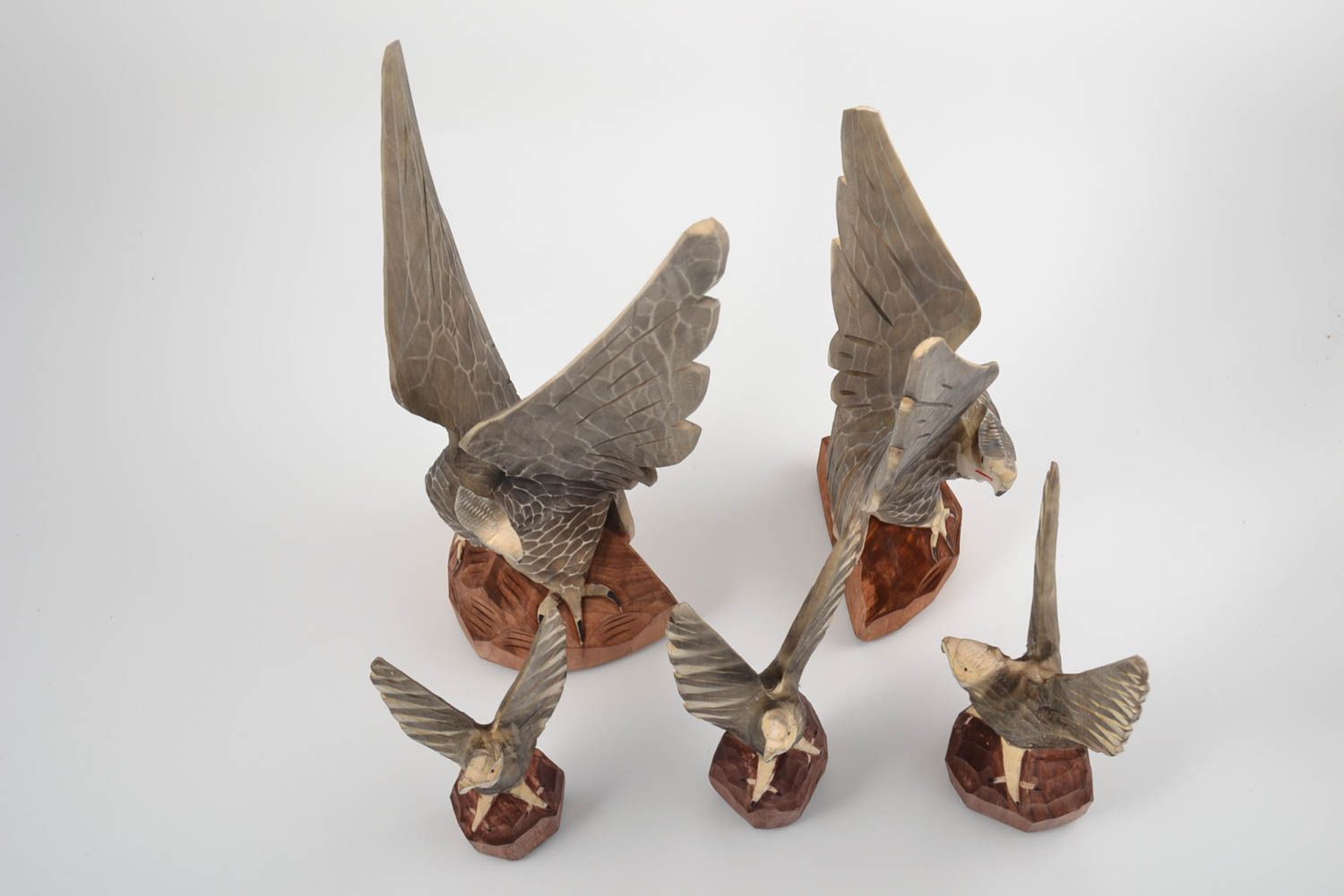 Conjunto de figuras de madera hechos a mano con forma de águilas de diferentes tamaños foto 3