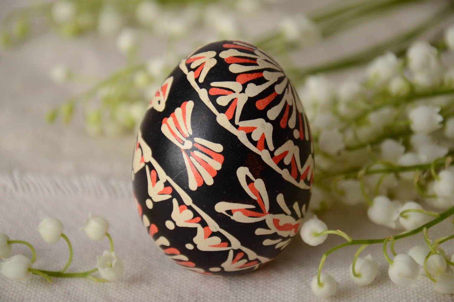 Handmade painted Easter egg of black color with patterns waxing technique photo 1