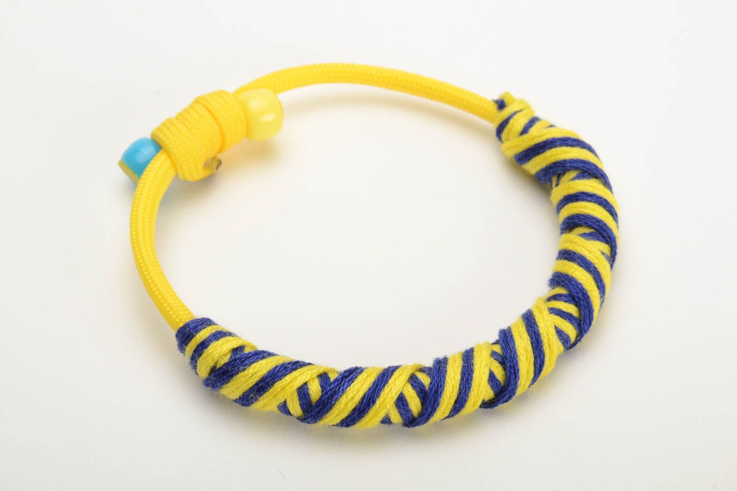 Pulsera artesanal trenzada de hilos mouliné con paracord de colores azul y amarillo  foto 4