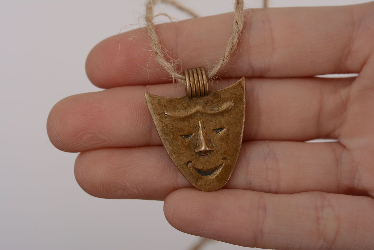 Bronze pendant in the shape of a mask photo 5