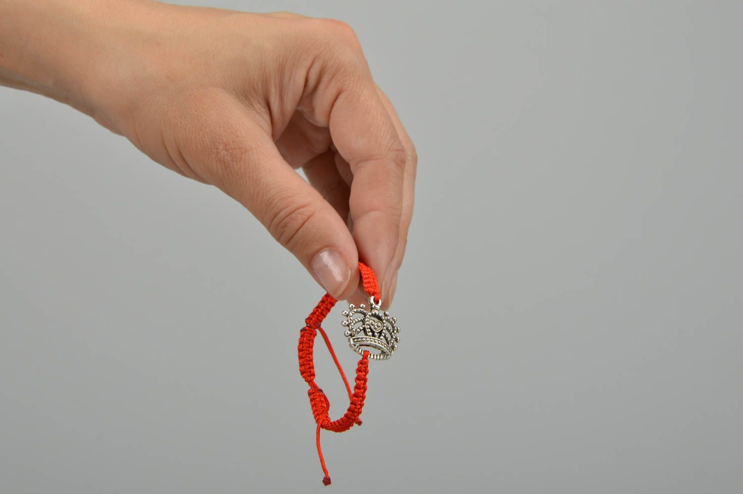 Bracelet fait main tressé en lacet ciré rouge avec couronne métallique design photo 2
