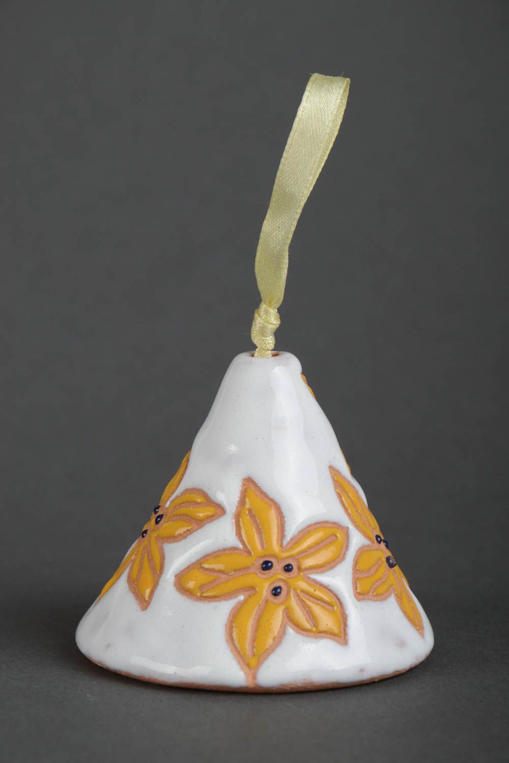 Handmade decorative ceramic bell painted with yellow flowers on white background photo 2