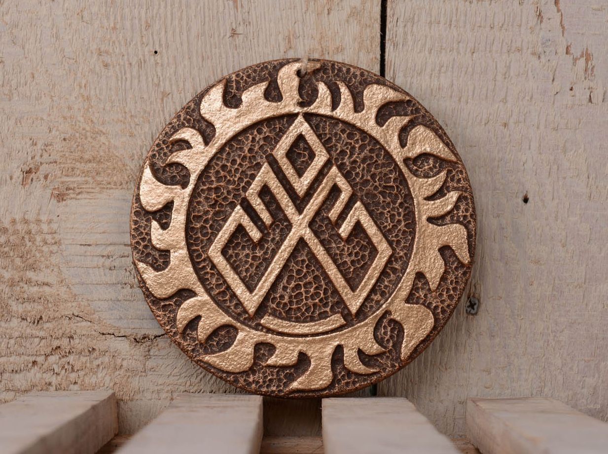 Prato decorativo de cerâmica com um símbolo eslavo para o bem-estar e harmonia foto 1