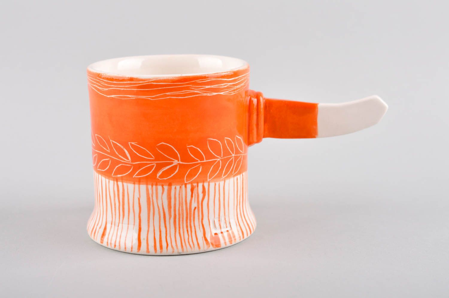 Art style porcelain drinking cup in orange and white color. Stick shape handle. photo 2