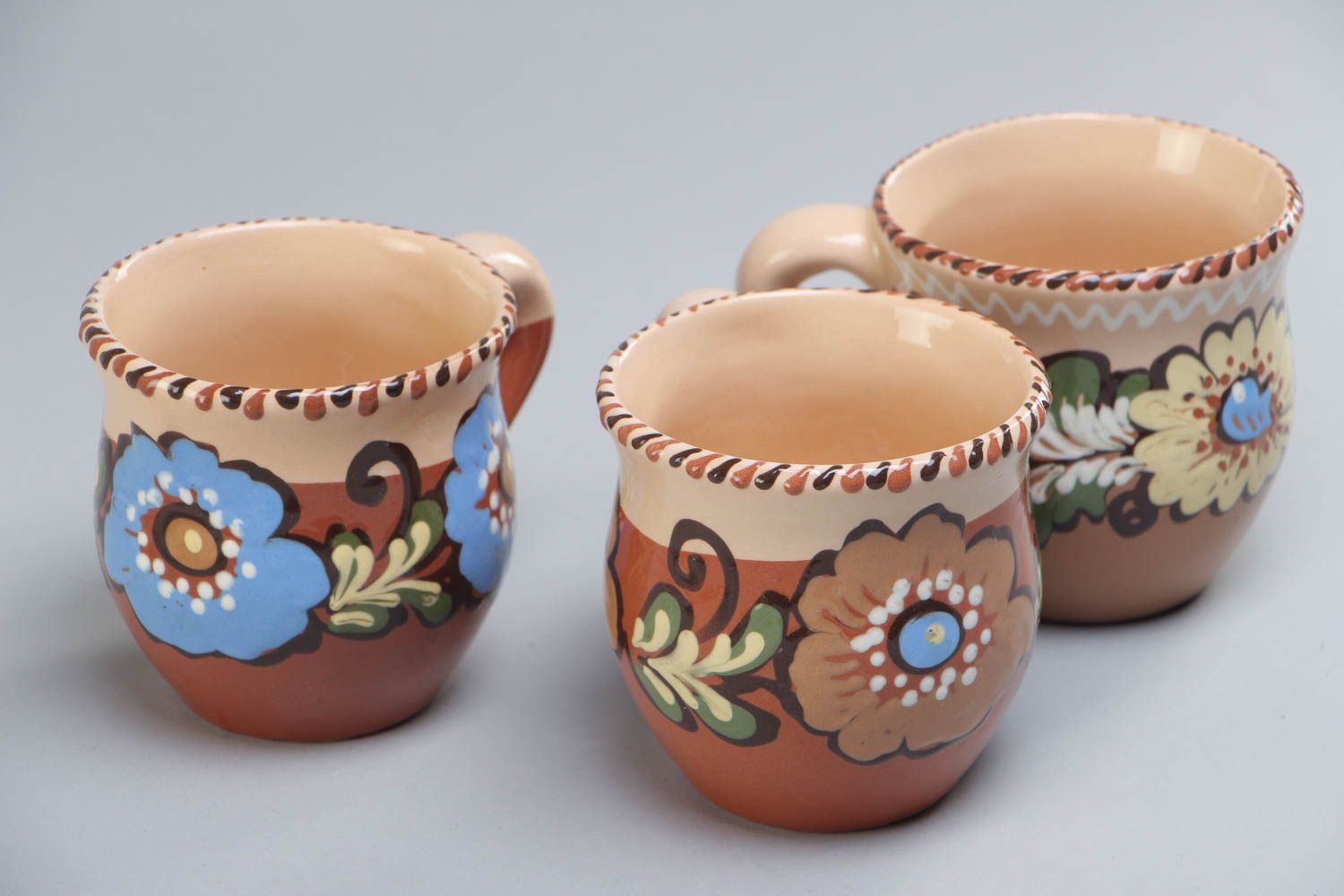 Set of three glazed village-style tea cups with painted flower pattern photo 2