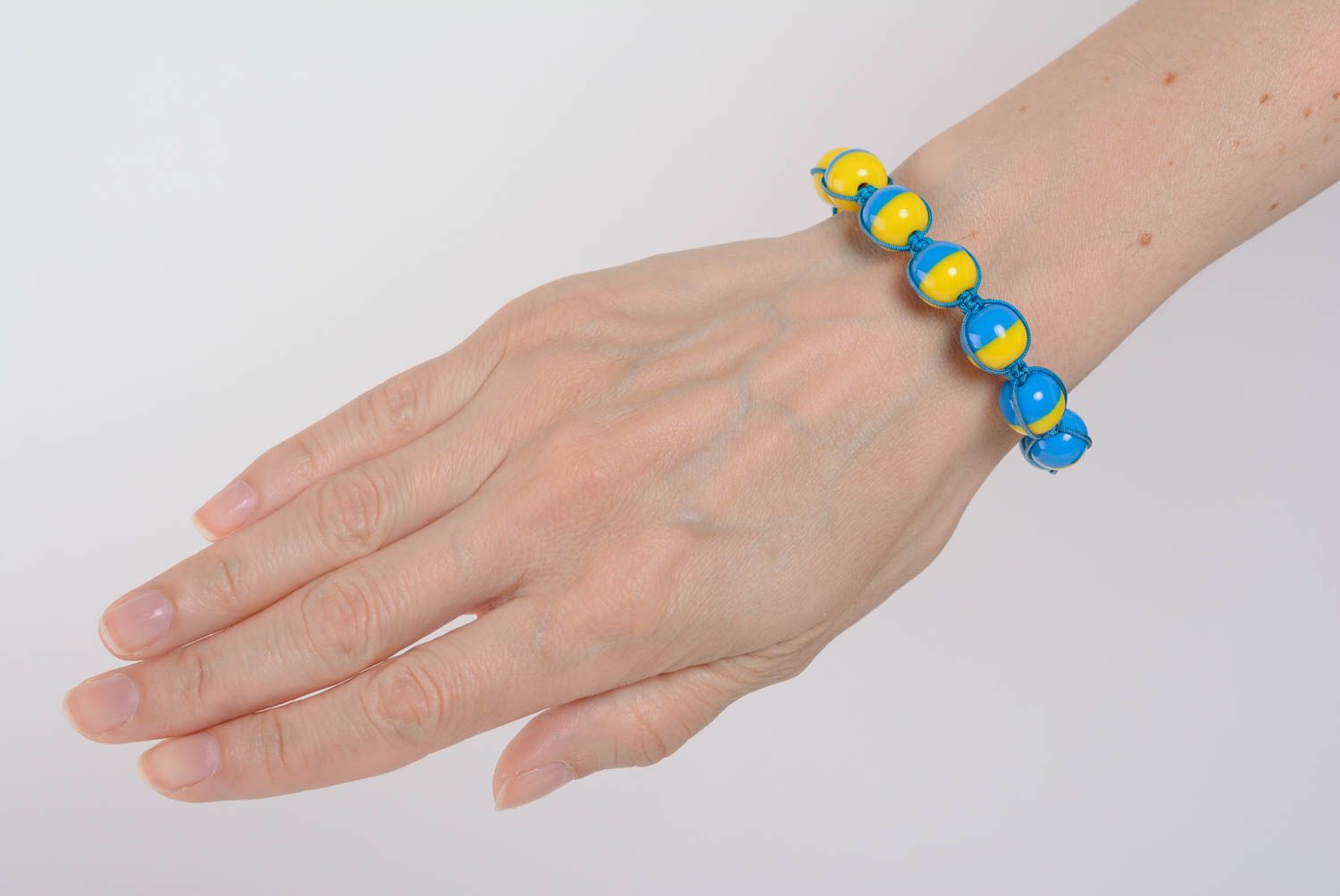Künstlerisches dünnes buntes Armband aus Plastik und Schnur in Blau und Gelb foto 5