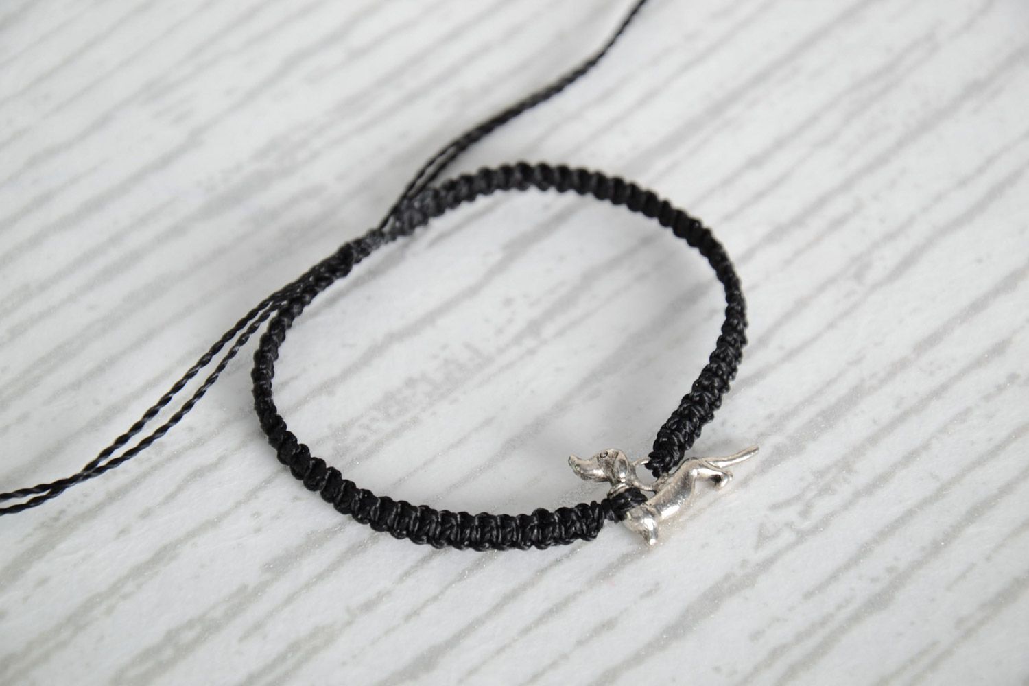 Handmade friendship bracelet woven of gray threads with a badger-dog charm photo 1