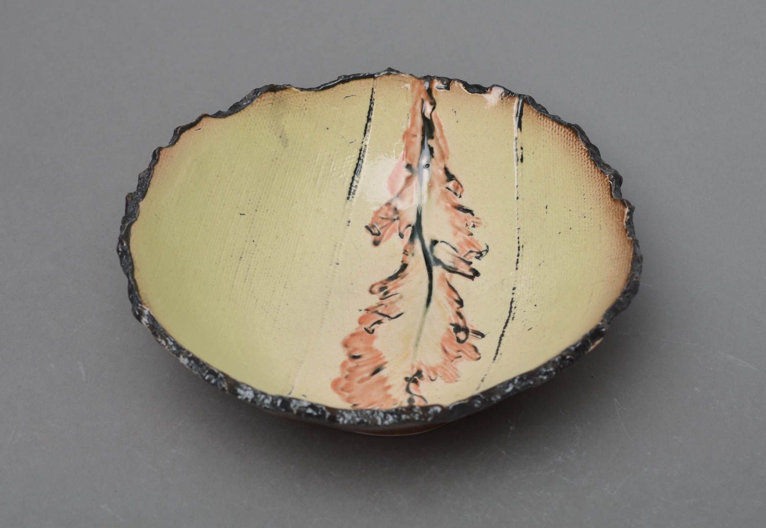 Plato de porcelana artesanal beige con dibujo en fondo con borde ondulado foto 1