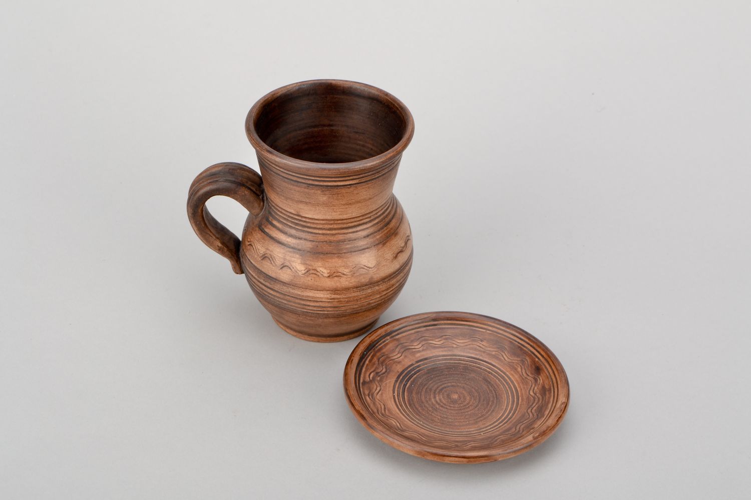 Ceramic cup in pitcher shape with handle and saucer in rustic pattern photo 4