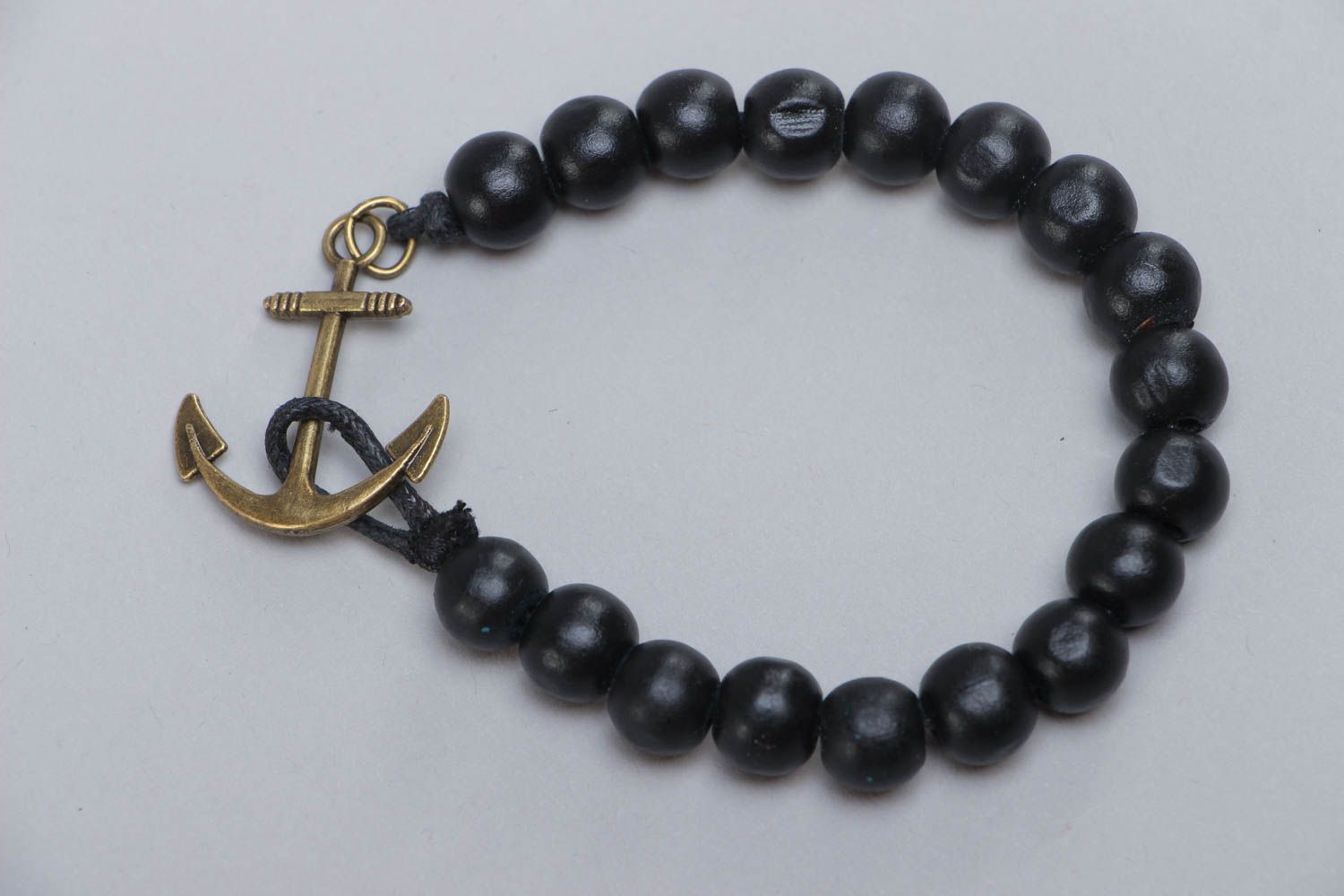Handmade stylish black bracelet made of wooden beads with metal anchor photo 2