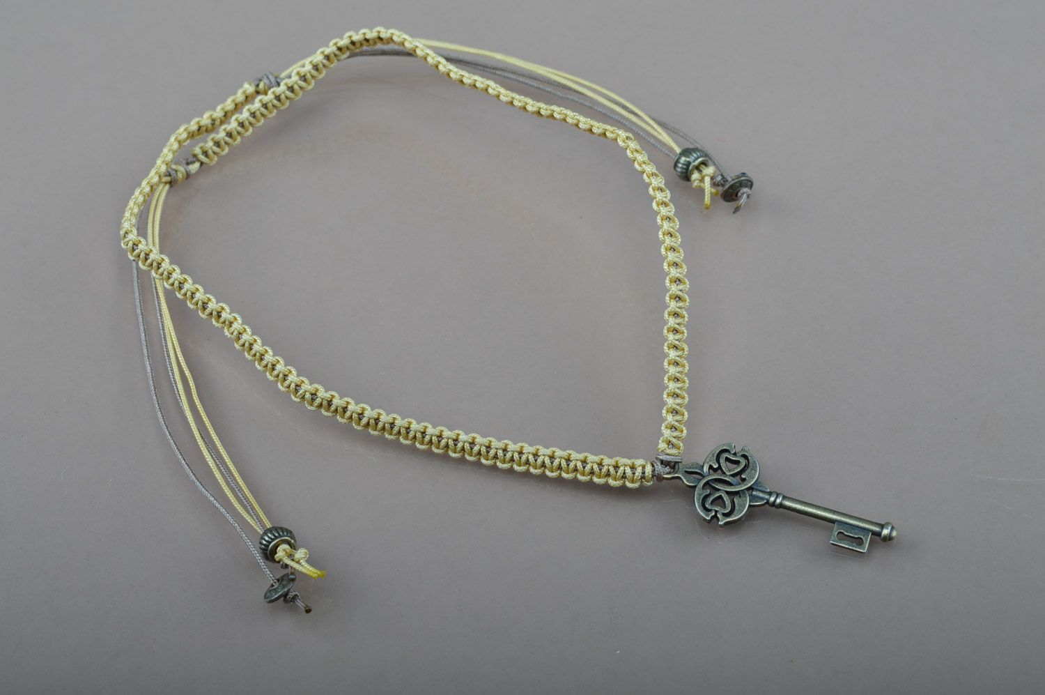 Handmade friendship wrist bracelet woven of cord with metal key-shaped charm photo 2